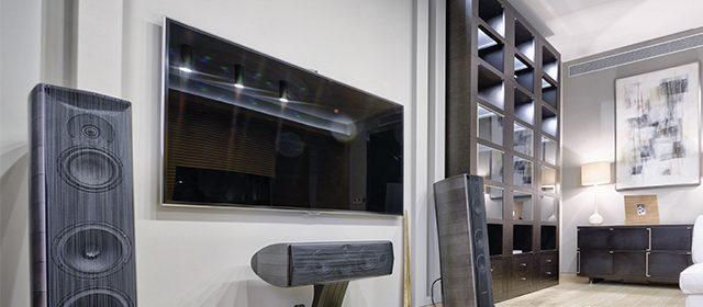 televozor-sa-zvucnicima Par u zamračenoj sobi gleda film na TV-u sa surround sistemom