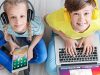 Dečak i devojčica sede na podu i nasmejani koriste slušalice, tablet i laptop